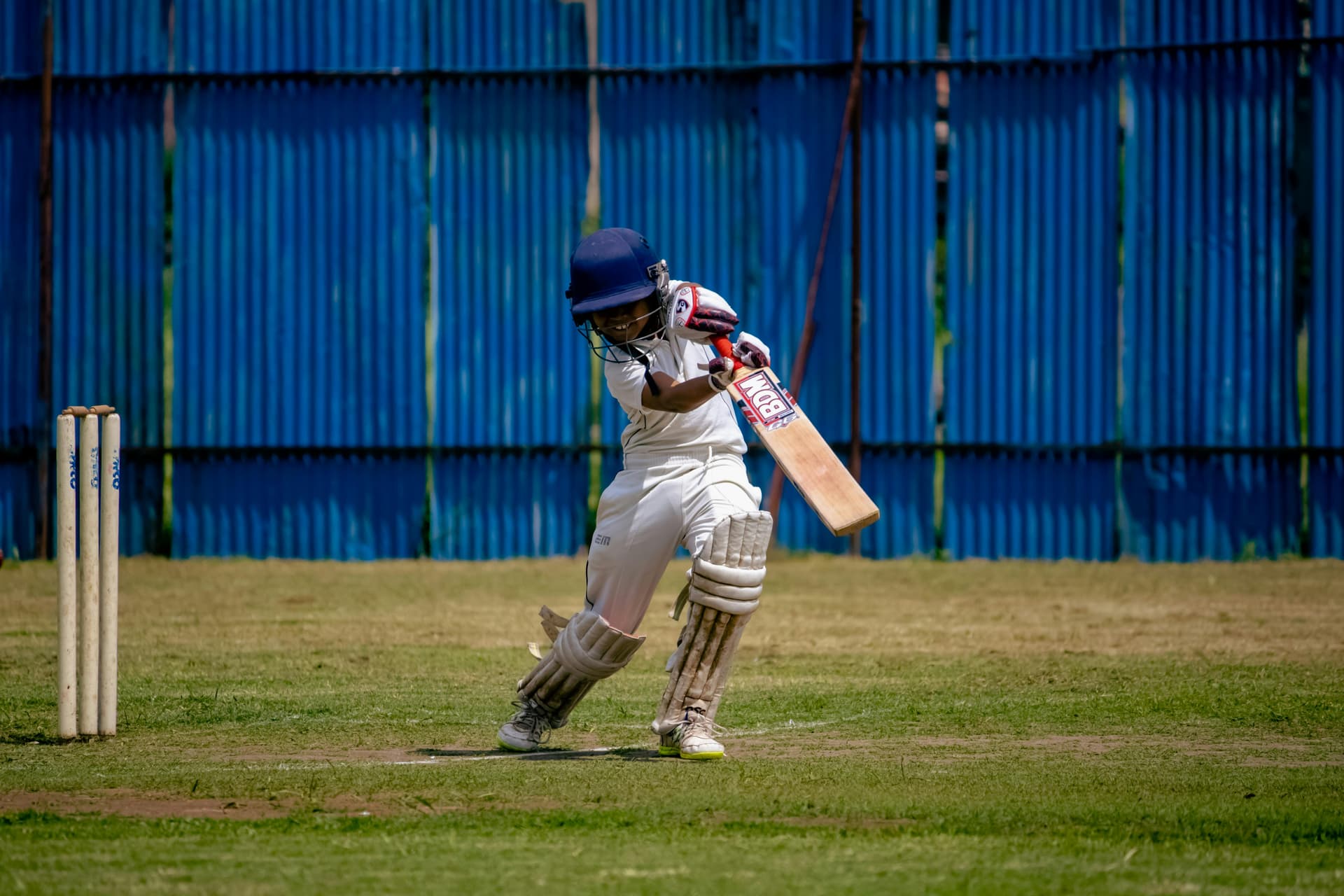 Young boy batting with blue background