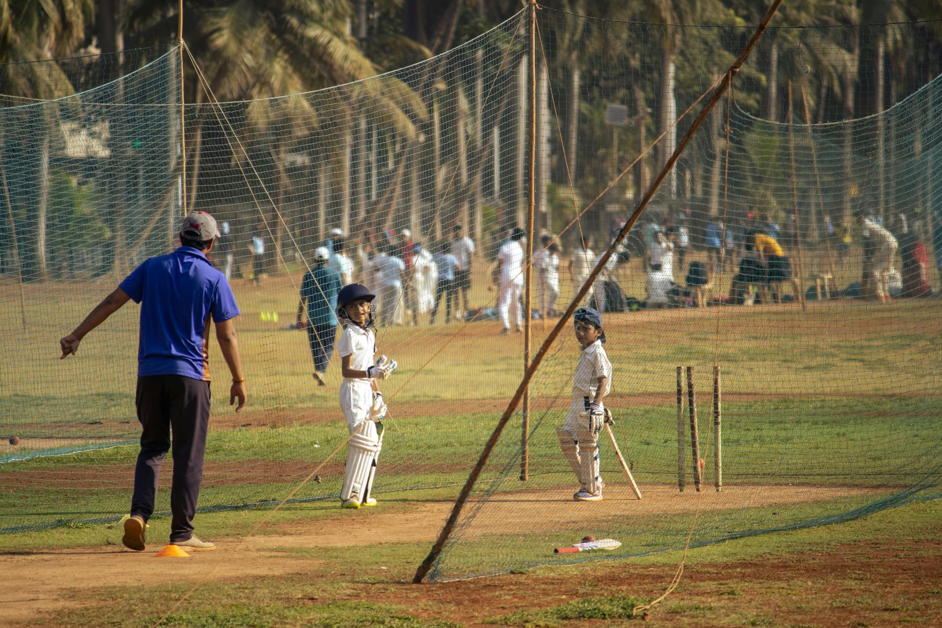 Cricket coach working with young players in the nets
